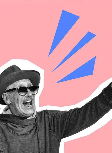 Black and white photo of a smiling man in sunglasses and hat against a pink background. The man is promoting an event with flyers.